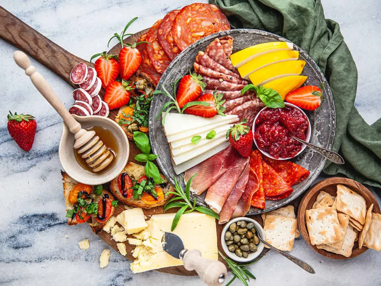 En h&auml;rlig anti pasti-bricka med charkuterier, ost, jordgubbar, marmelad och kex.