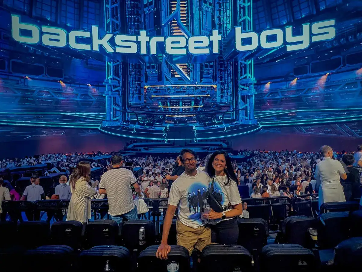Para z uśmiechem na koncercie Backstreet Boys. W tle wielki napis 