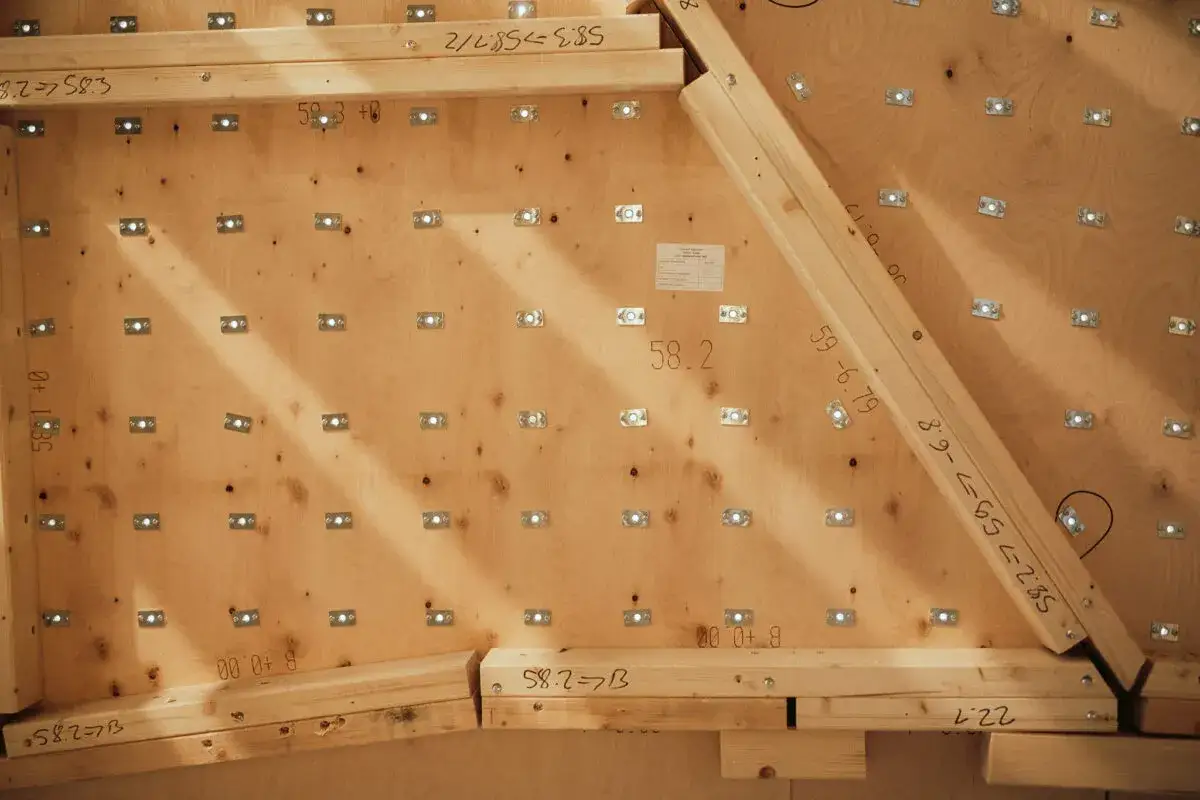 Holzkonstruktion f&uuml;r eine Kletterwand selber bauen. Viele kleine Metallplatten sind auf Sperrholz befestigt.