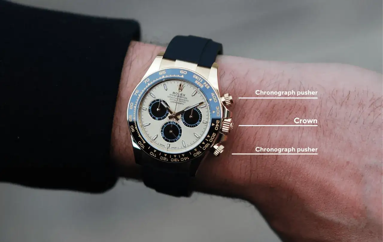 Detalle de un reloj Rolex Daytona dorado con correa negra, mostrando cómo ajustar reloj automático usando la corona y los pulsadores.