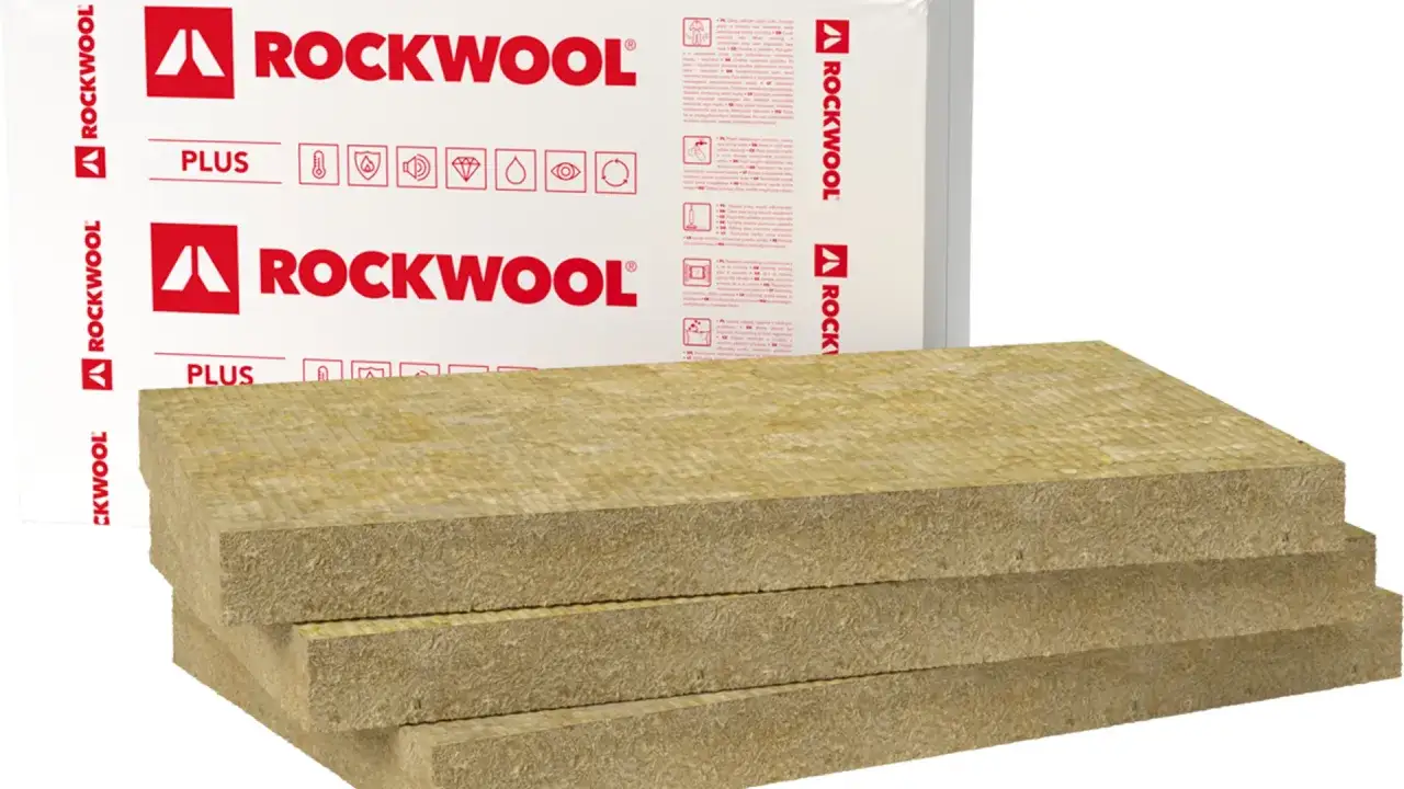 Trzy płyty wełny skalnej ROCKWOOL PLUS ułożone jedna na drugiej. Opakowanie z logo ROCKWOOL w tle.