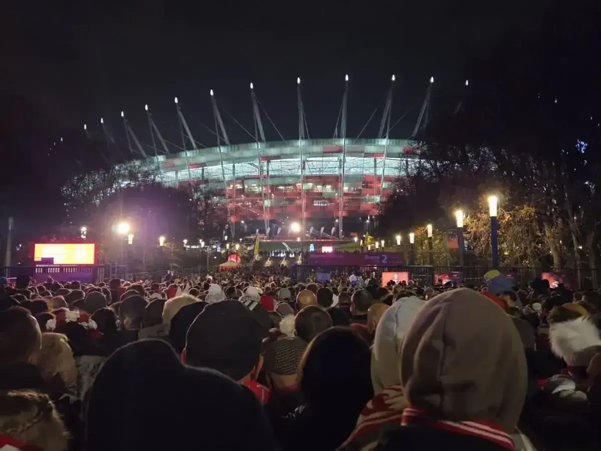 Tłumy ludzi zmierzają na Stadion Narodowy, by uczestniczyć w ekscytujących wydarzeniach.