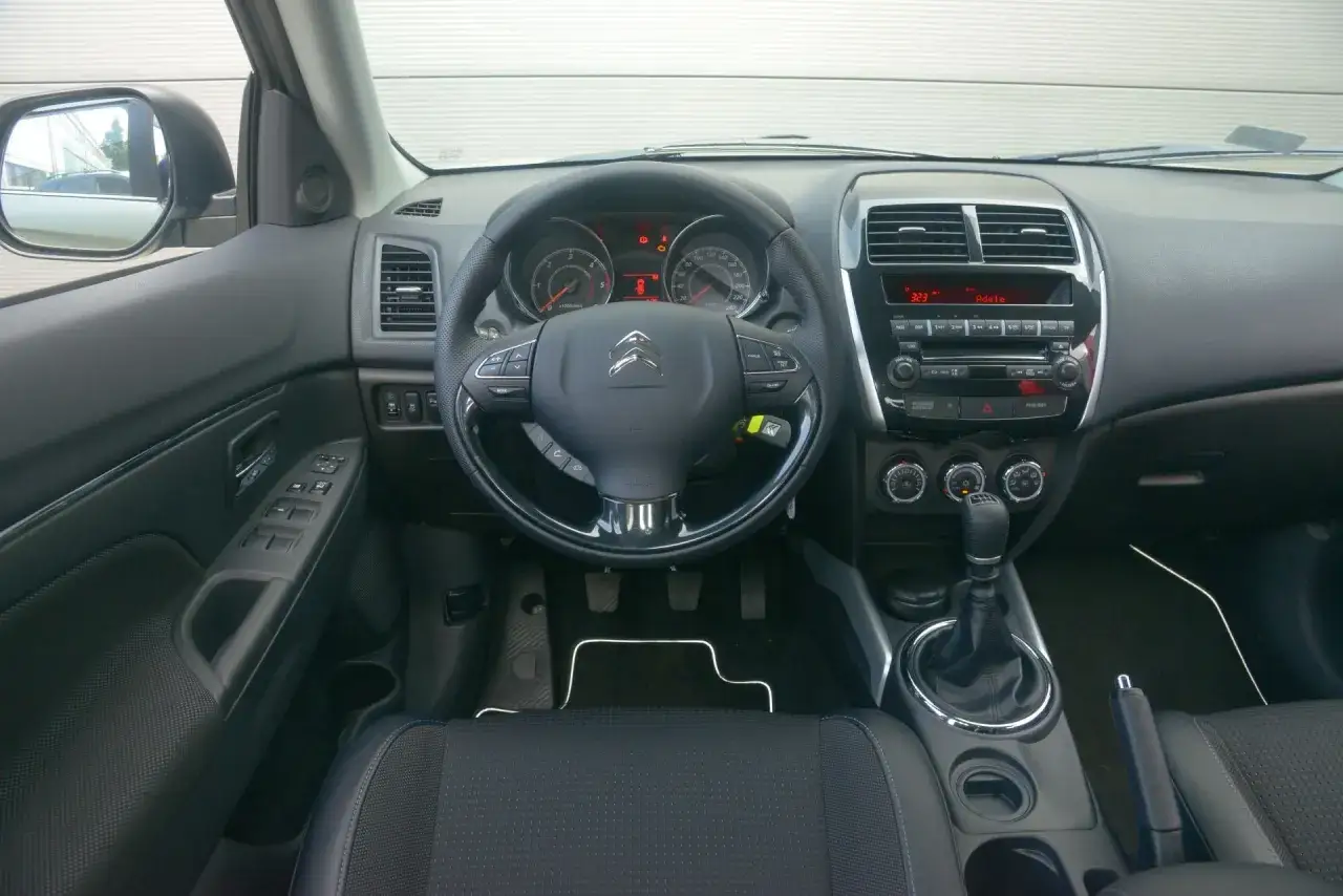 Wnętrze Citroen C4 Aircross: kierownica, deska rozdzielcza z radiem i nawiewami, dźwignia zmiany biegów.