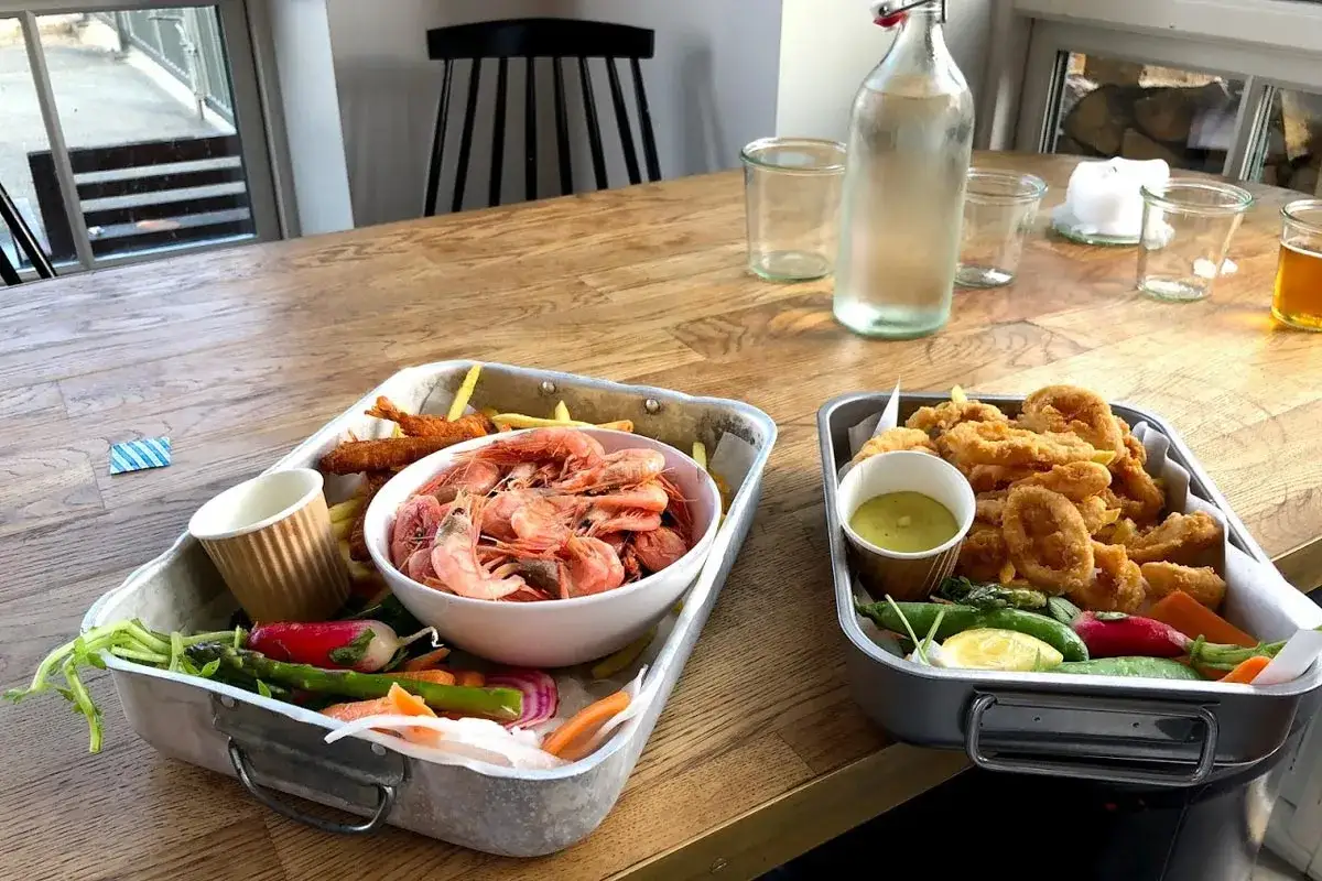 Dos bandejas con comida t&iacute;pica de Dinamarca: gambas, calamares fritos y verduras frescas.