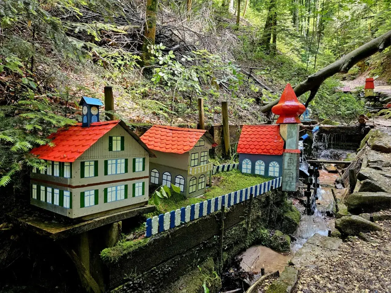 Miniaturh&auml;user mit roten D&auml;chern am Bachlauf der Schelmenklinge Lorch, ein m&auml;rchenhafter Anblick im Wald.