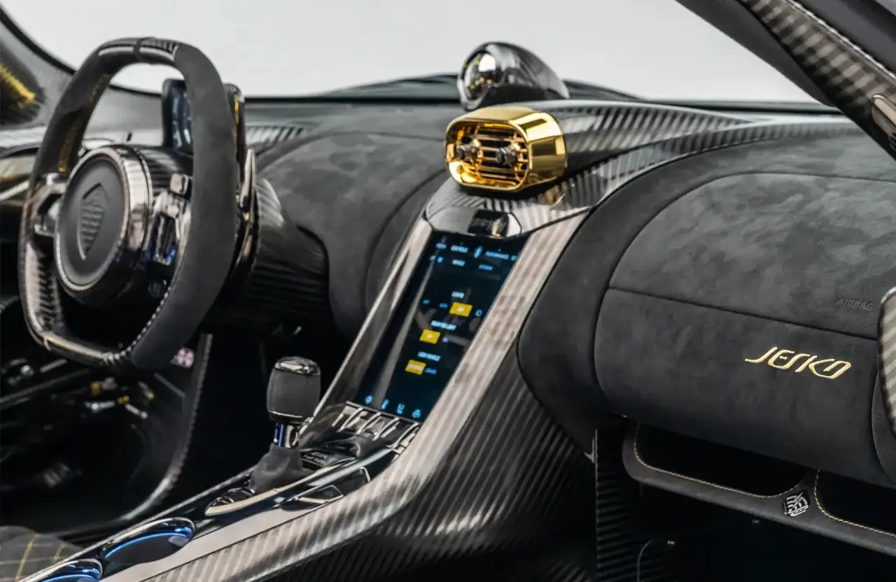 Wnętrze Koenigsegg Jesko: kierownica, ekran dotykowy, złote detale i wykończenie z włókna węglowego.