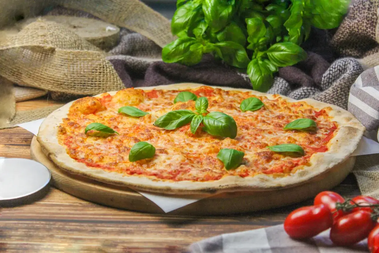 Pyszna pizza Margherita z pomidorami i bazylią. Idealne składniki, by wiedzieć, co położyć na pizzę dla klasycznego smaku.