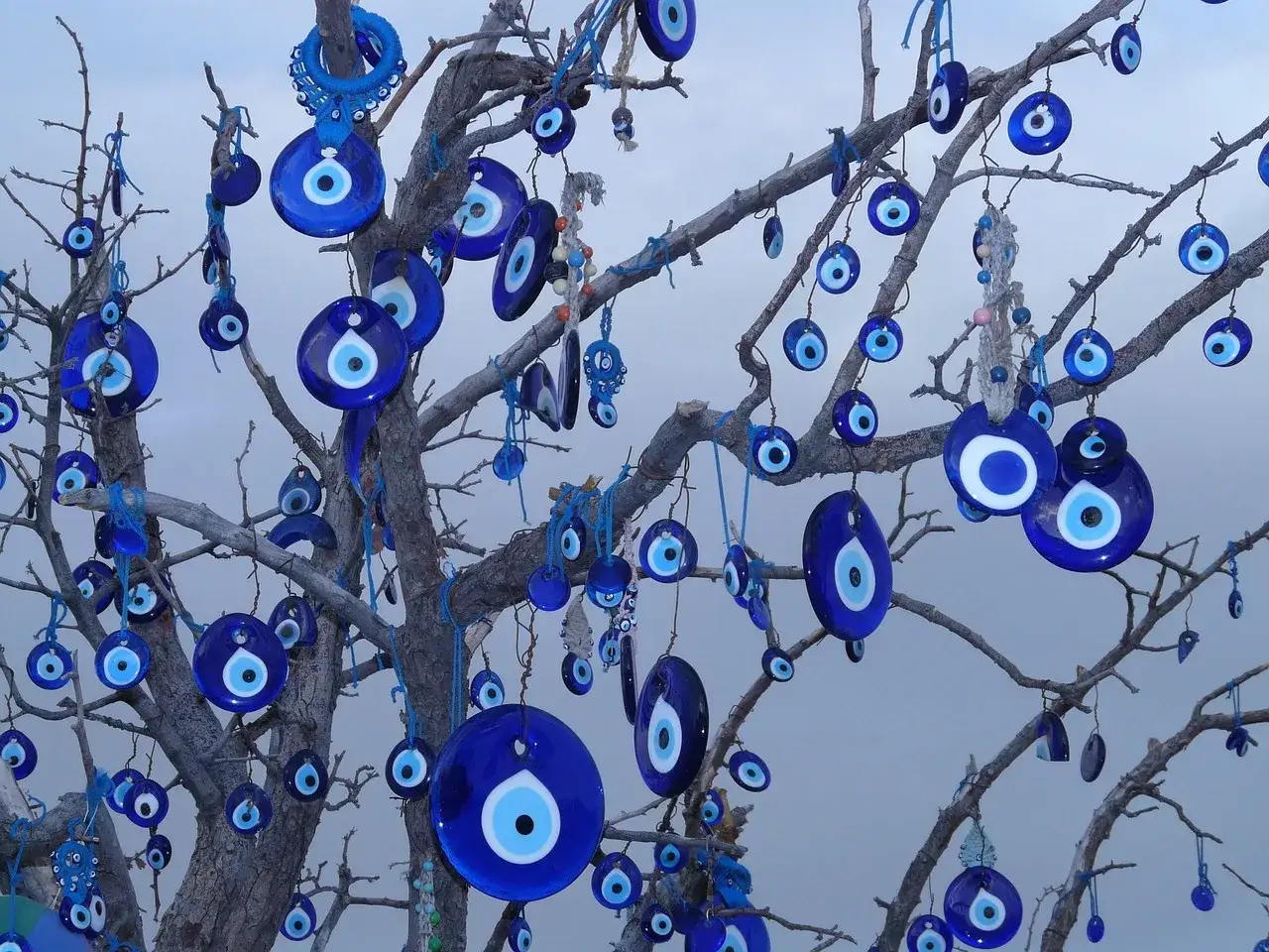 Ein Baum voller blauer Glasanh&auml;nger, die wie ein **arabisches Auge** aussehen, h&auml;ngt an kahlen &Auml;sten.