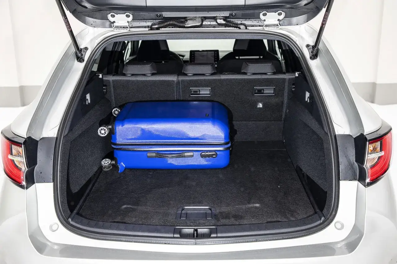 Bagażnik Suzuki Swace Hybrid z niebieską walizką. Idealny na podróż!