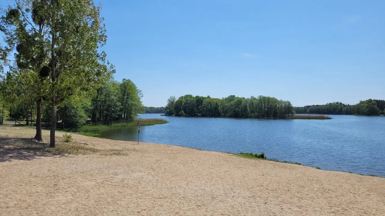 Piękna plaża nad jeziorem, idealne miejsce na wypad na weekend wielkopolska. Słońce, woda i zieleń.