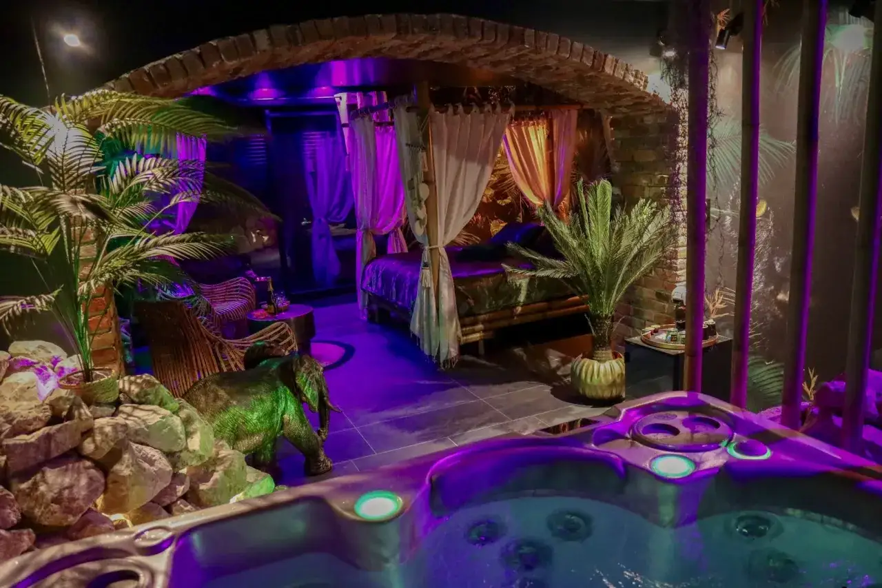 Une nuit insolite dans le nord : jacuzzi, lit baldaquin, éléphant décoratif et végétation luxuriante créent une ambiance tropicale.