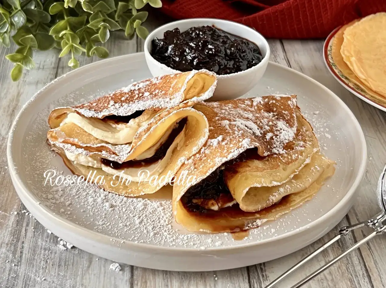 Deliziose crepes senza uova, ripiene di crema e marmellata, spolverate di zucchero a velo. Un dolce invitante e leggero.