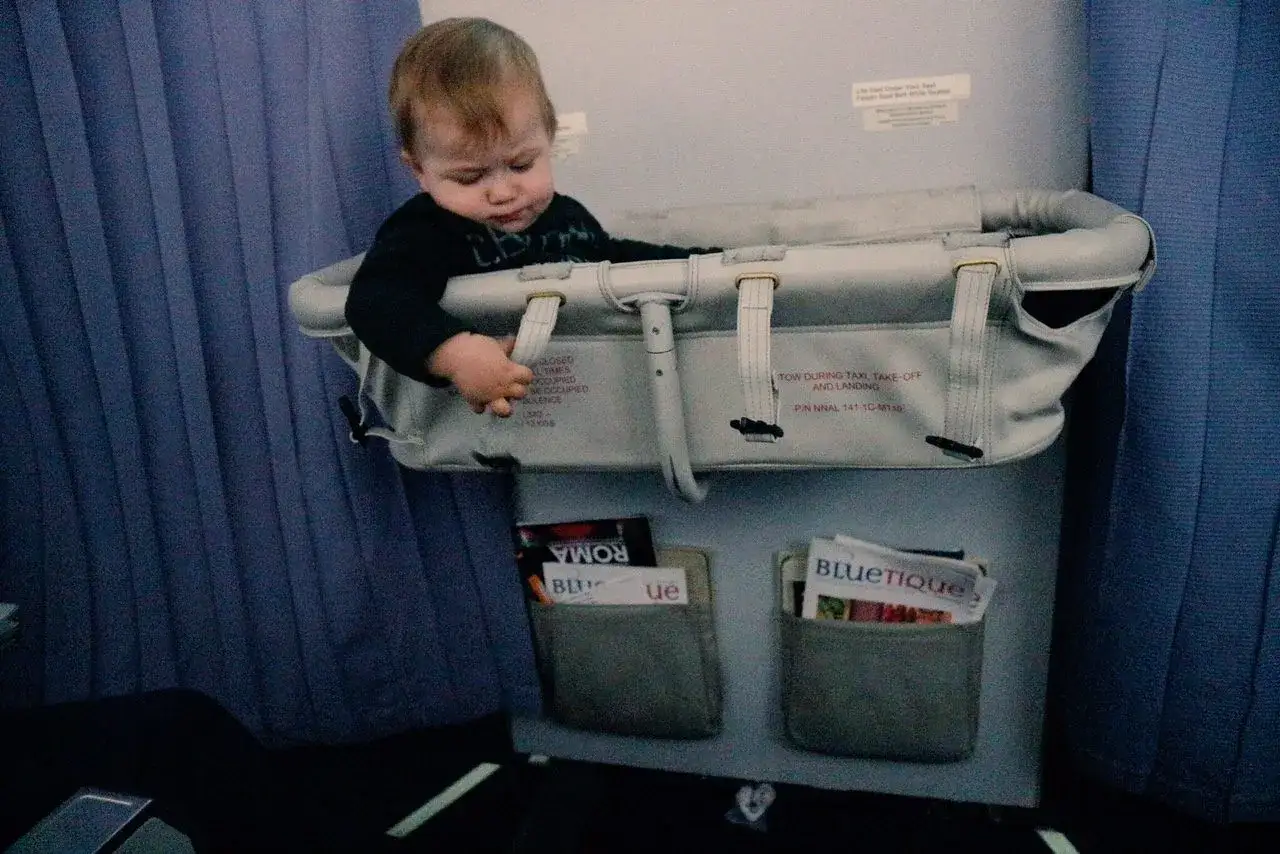 Un aereo neonato di 6 mesi, seduto in una navicella, guarda curioso il mondo da un finestrino.