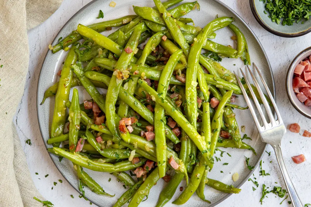 Frisch zubereitete Buschbohnen kochen mit Speckw&uuml;rfeln und Petersilie. Ein leckeres Gericht, das Appetit macht.