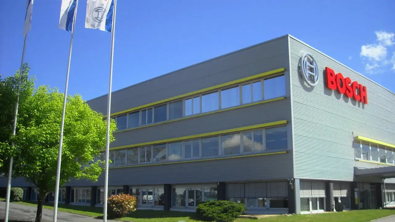 Bâtiment moderne avec le logo Bosch bien visible. L'image évoque la fabrication et l'innovation de Bosch.