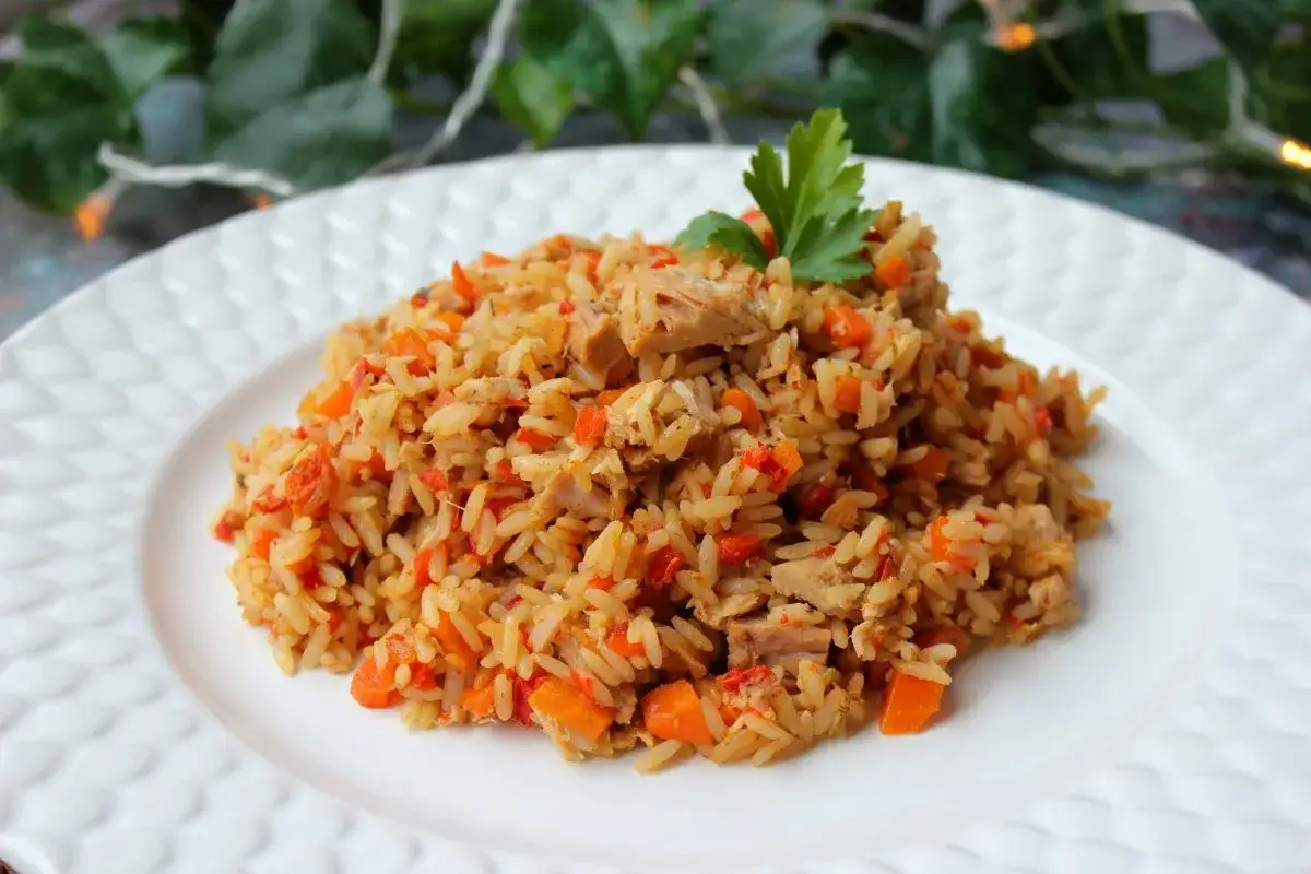 Arroz con bonito de lata, zanahoria y pimiento rojo, decorado con perejil. Un plato sencillo y sabroso.