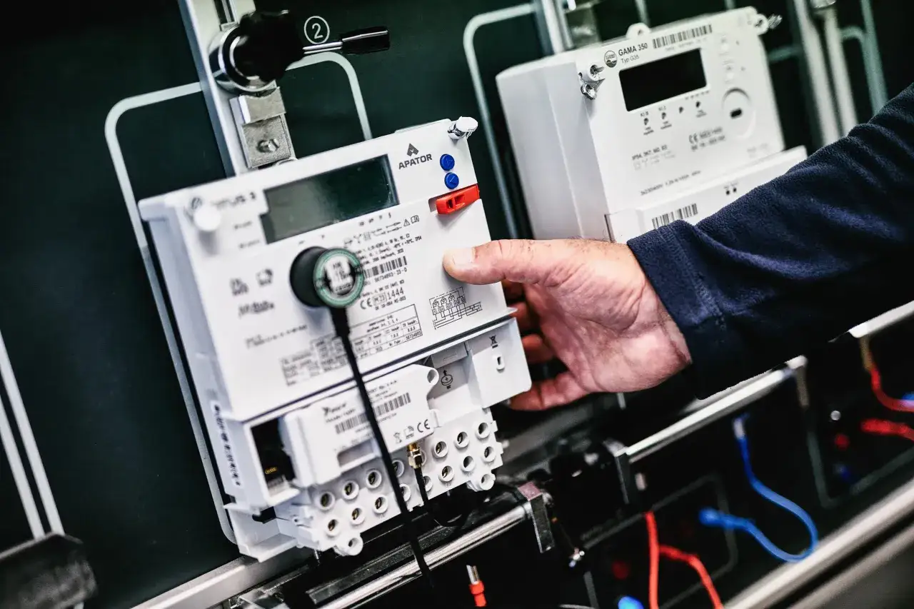 Dłoń manipuluje licznikiem zdalnego odczytu PGE. Nowoczesne urządzenia do monitorowania zużycia energii.
