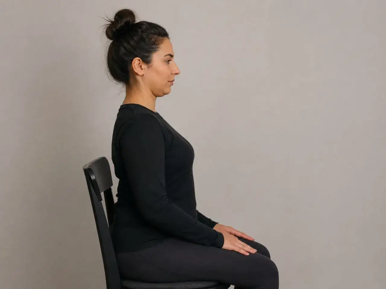 Femme assise, profil droit, pour soulager maux de tête et cervicales. Posture détendue.