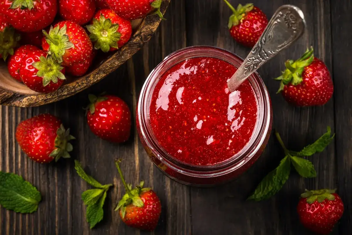 Frische Erdbeeren und ein Glas hausgemachte Erdbeermarmelade. Ein einfaches Erdbeermarmelade Rezept f&uuml;r den Sommer.