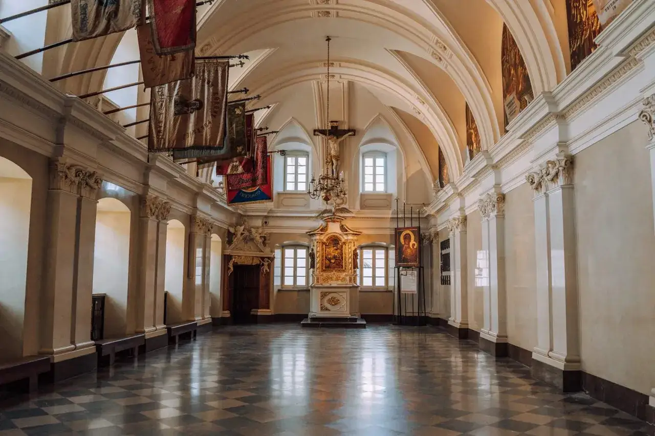 Wnętrze z ołtarzem, krucyfiksem i sztandarami. Jedno z miejsc, kt&oacute;re warto zobaczyć, odkrywając częstochowa atrakcje.
