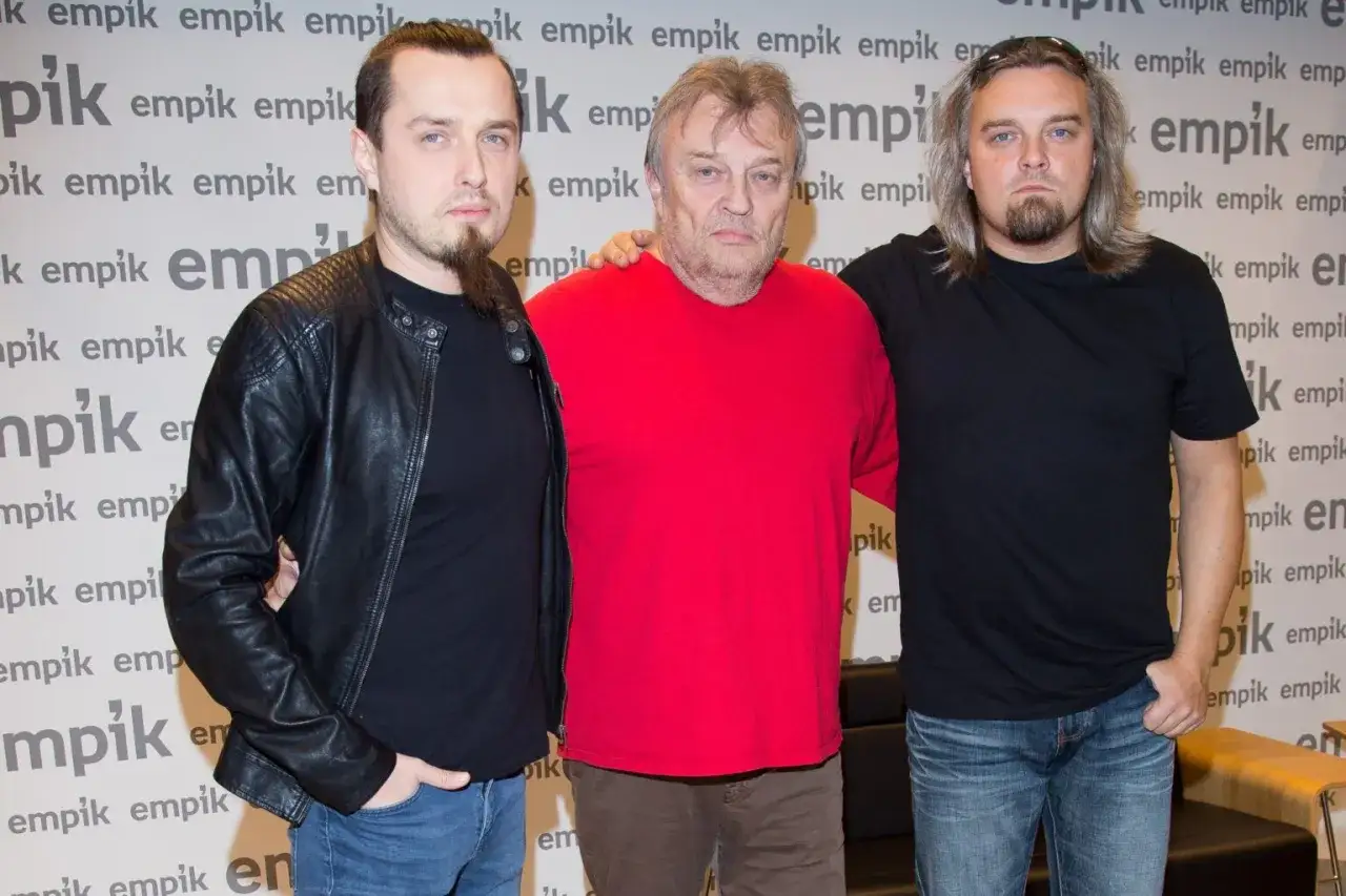 Trzech członków zespołu muzycznego Bracia pozuje do zdjęcia.