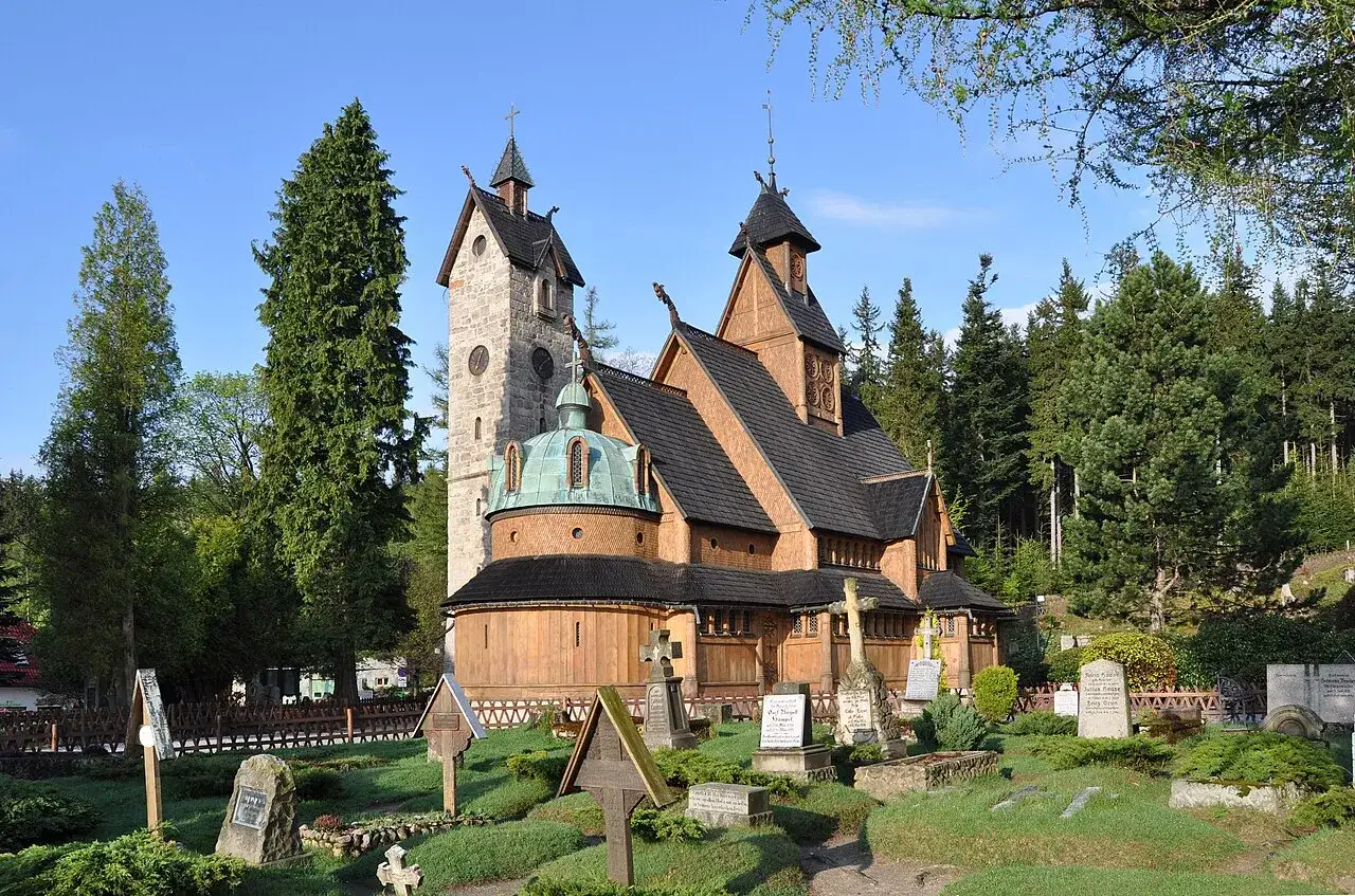 Drewniana świątynia Wang w Karpaczu, otoczona cmentarzem i lasem. Ciekawostki o jej budowie i historii przyciągają turystów.