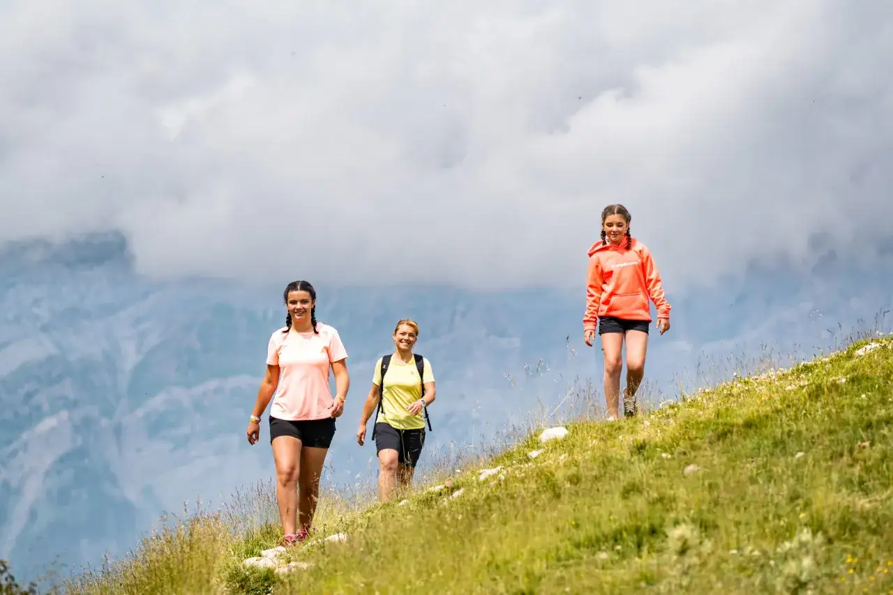 Tres mujeres disfrutan de una caminata en la montaña, una idea genial para saber qué hacer en Benasque con niños.
