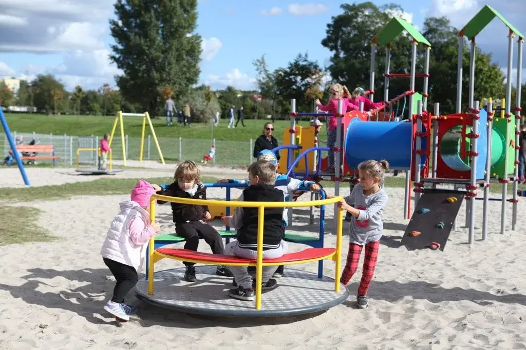 Dzieci bawiące się bezpiecznie na placu zabaw