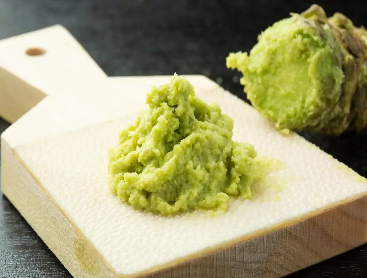 Świeżo starty wasabi na desce. Czy wasabi jest zdrowe? Tak, zawiera związki o właściwościach antybakteryjnych i przeciwzapalnych.