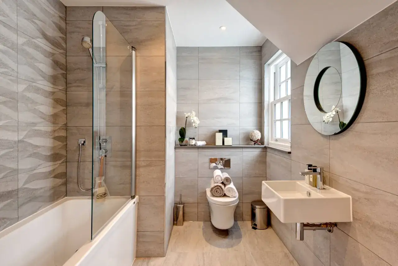 Ba&ntilde;o moderno con ba&ntilde;era, lavabo flotante y WC. La cisterna empotrada del inodoro es un ejemplo de los tipos de cisternas wc.
