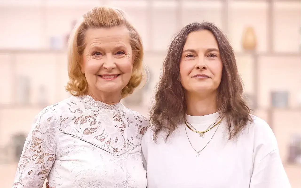 Barbara Bursztynowicz z córką, uśmiechnięte, stoją obok siebie.