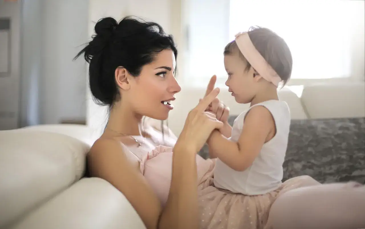Mama czule patrzy na swoje dziecko 3 lata nie m&oacute;wi, dotykając jego paluszka.
