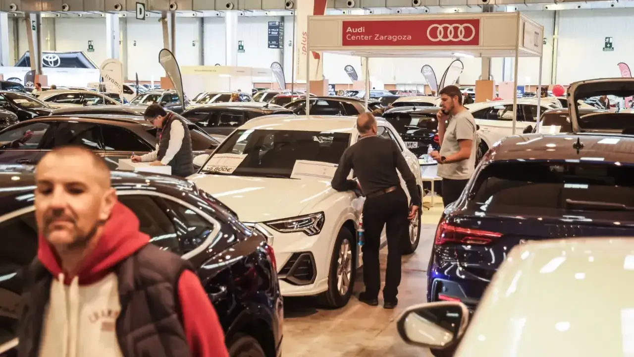 Gente observando coches en la exposicion coches zaragoza. Un hombre habla por tel&eacute;fono cerca de un Audi.