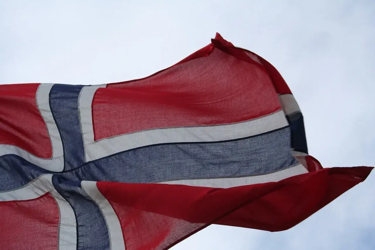 Flaga Norwegii faluje na wietrze. To symbol wolności i dumy, jak rejestracja samochodu z tego kraju.