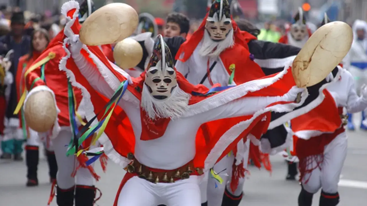 Personajes enmascarados con trajes rojos y blancos, portando instrumentos de percusi&oacute;n, celebran en Xinzo de Limia. &iexcl;Una experiencia &uacute;nica que ver en Xinzo de Limia!