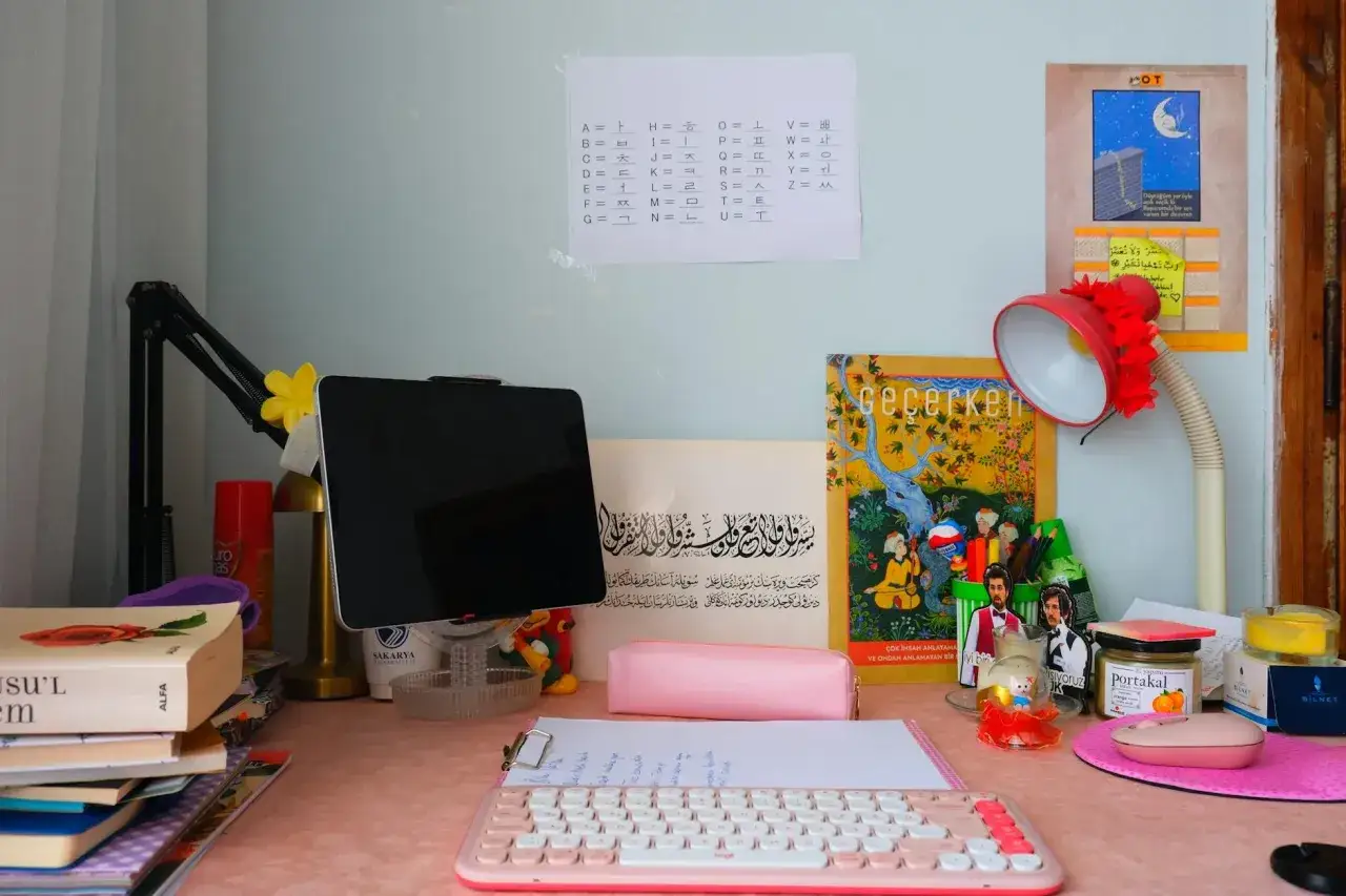 Biurko do nauczania domowego liceum: tablet, klawiatura, książki i notatki z alfabetem koreańskim.