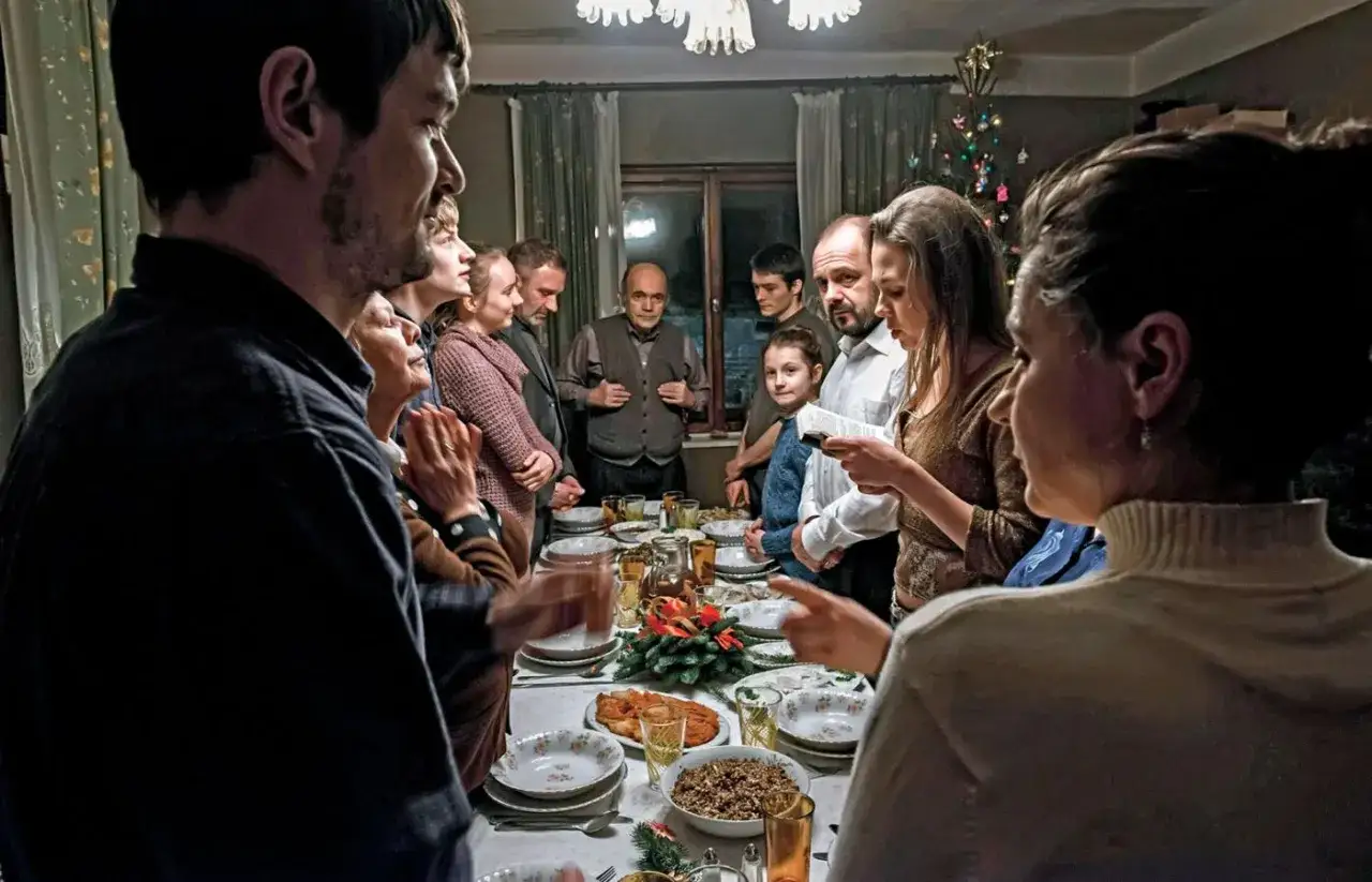Rodzina przy wigilijnym stole, scena z filmów Piotra Domalewskiego. Wszyscy zebrani, by wspólnie świętować.