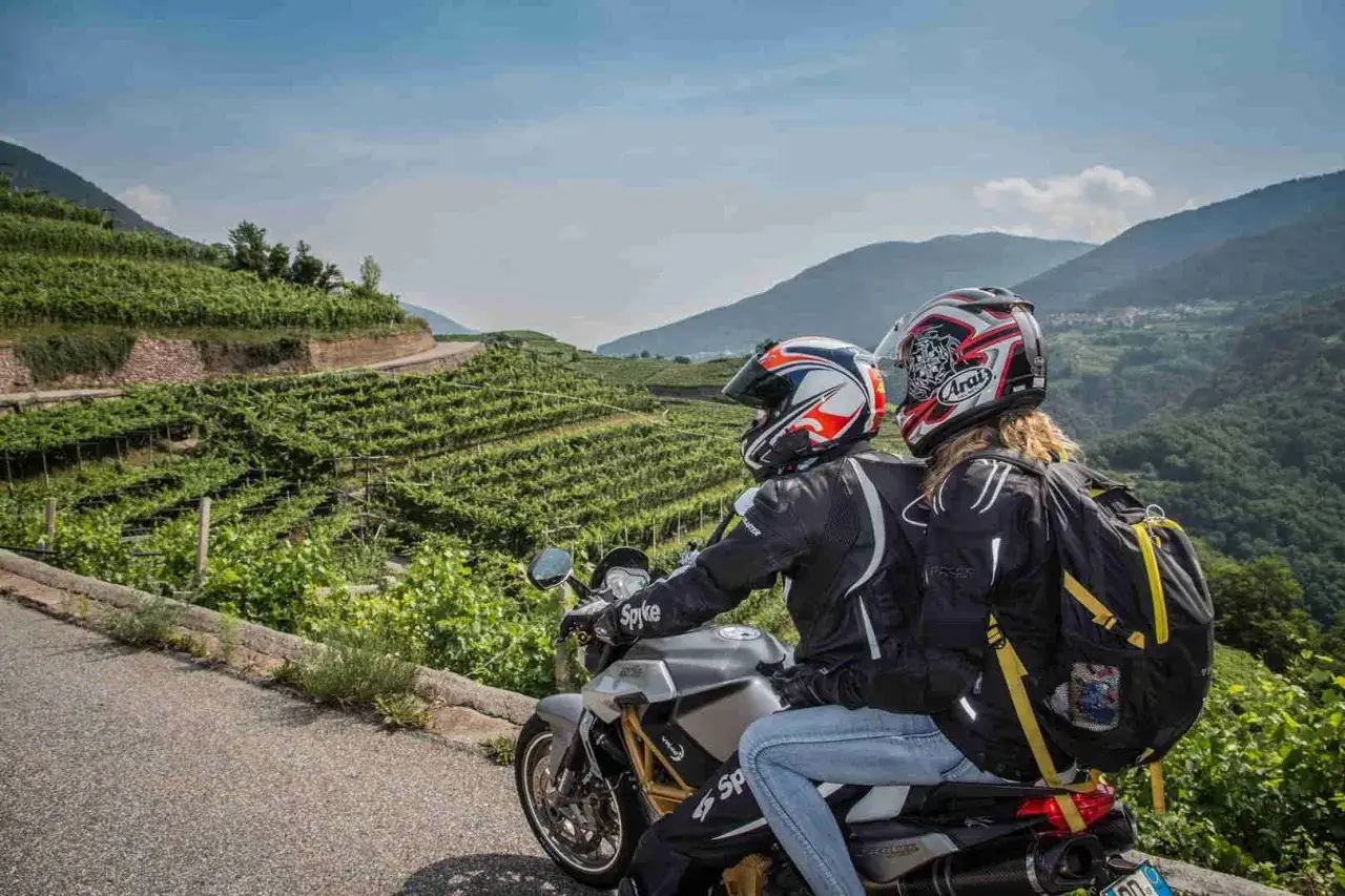 Coppia in moto esplora il Cilento, tra vigneti terrazzati e montagne verdi. Un'avventura panoramica.
