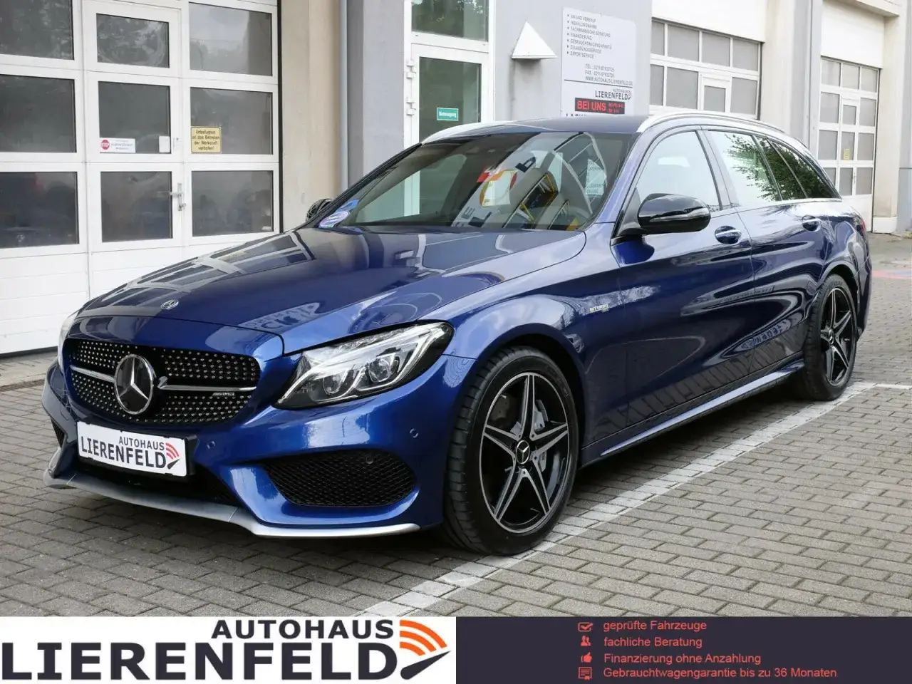 Blauer Mercedes-Benz C43 AMG Kombi vor Autohaus Lierenfeld. Technische Daten sind hier nicht sichtbar, aber das Fahrzeug gl&auml;nzt.