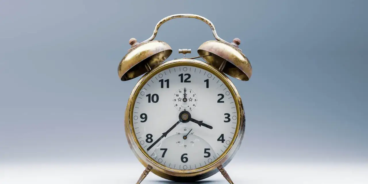 Reloj despertador antiguo, dorado, con dos campanas. Un ejemplo del primer reloj mec&aacute;nico, marcando las 10:08.