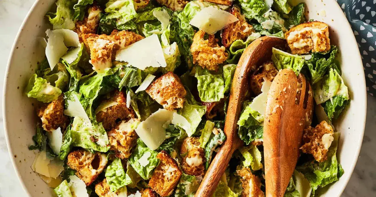 En n&auml;rbild av en kr&auml;mig caesarsallad med krispiga krutonger och parmesan. Perfekt f&ouml;r ett snabbt caesarsallad recept.
