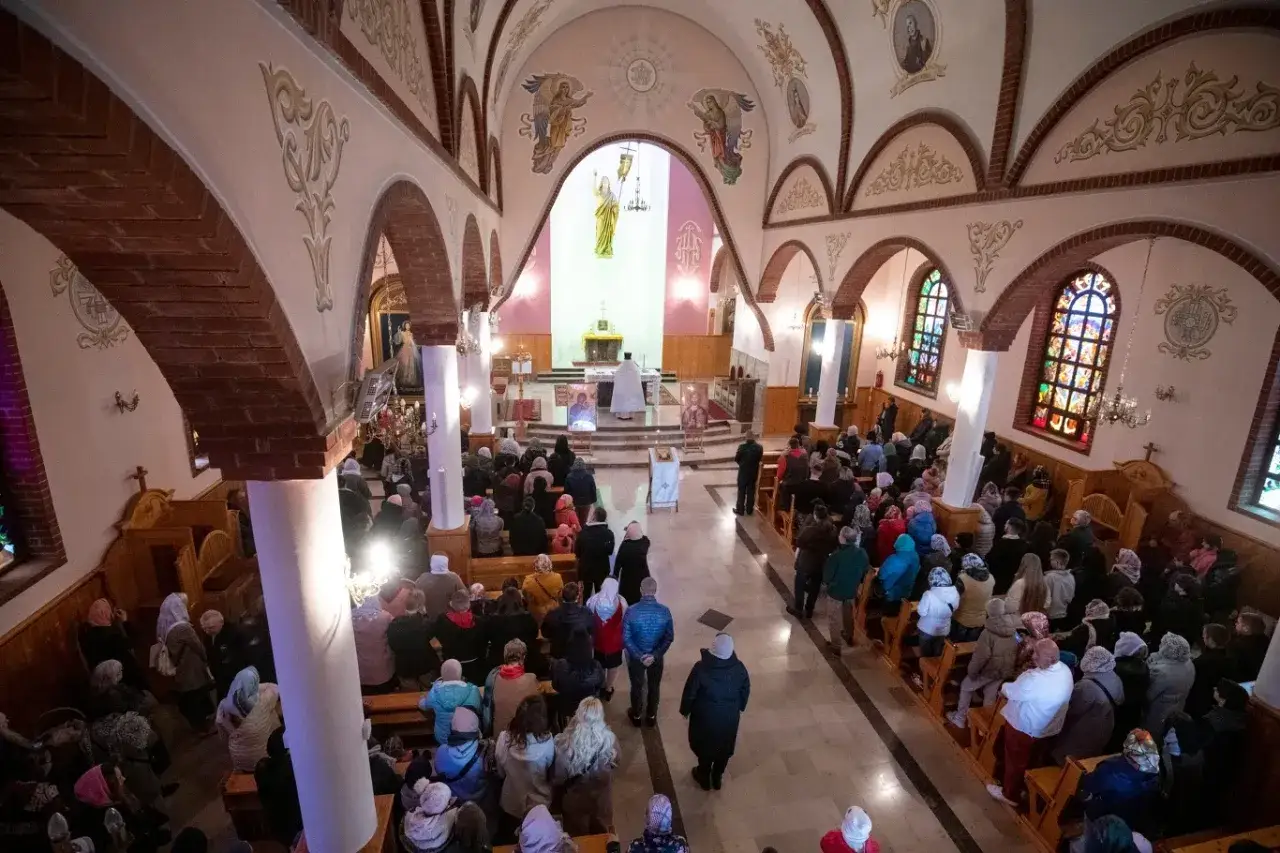 Wnętrze kościoła podczas uroczystości odpustowej. Wierni zgromadzeni na ławkach, przy ołtarzu kapłan.