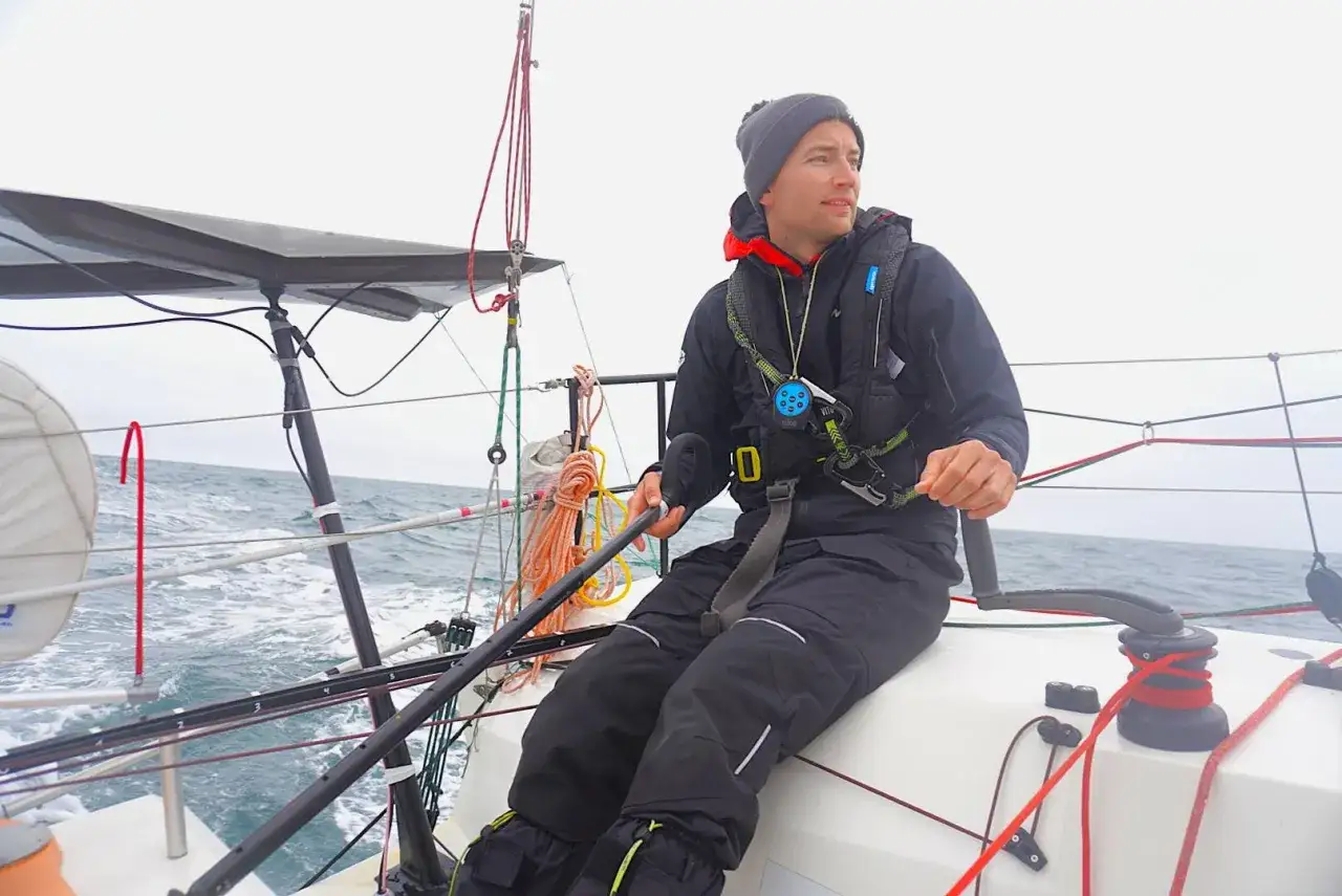 Mann am Steuer einer Segelyacht, bereit für das Mini Transat Abenteuer.