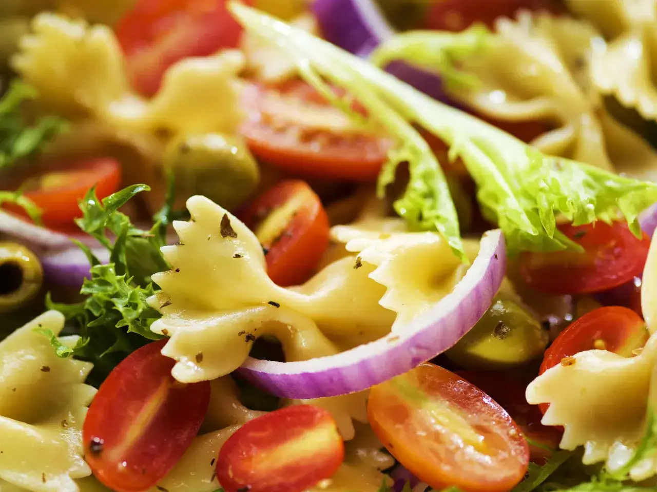 Leckere schnelle Salate ohne Mayo: Farfalle-Nudeln mit Kirschtomaten, Oliven, roten Zwiebeln und knackigem Salat. Ein Genuss!