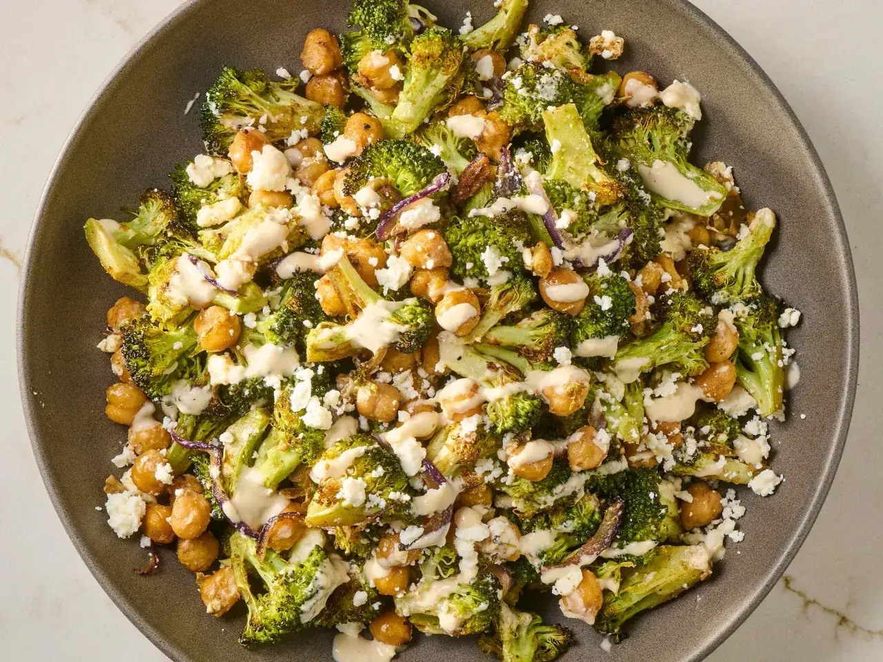 Ger&ouml;steter Brokkoli und Kichererbsen mit zerbr&ouml;ckeltem Feta und cremiger Tahini-Dressing. Ein k&ouml;stlicher Brokkoli Kichererbsen Salat.