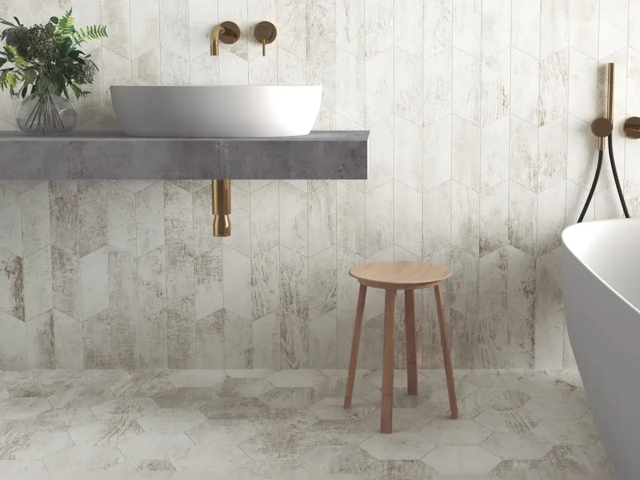Baño moderno con lavabo sobre encimera de hormigón y grifería dorada. Las paredes y el suelo están revestidos con **azulejos Oporto** de diseño hexagonal y aspecto madera desgastada.