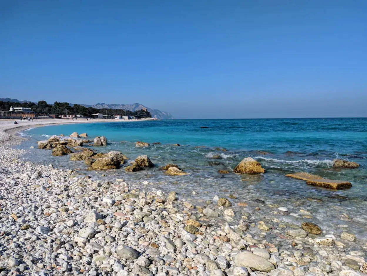 Portonovo, tra le spiagge più belle, con ciottoli bianchi e un mare turchese che invita a tuffarsi.