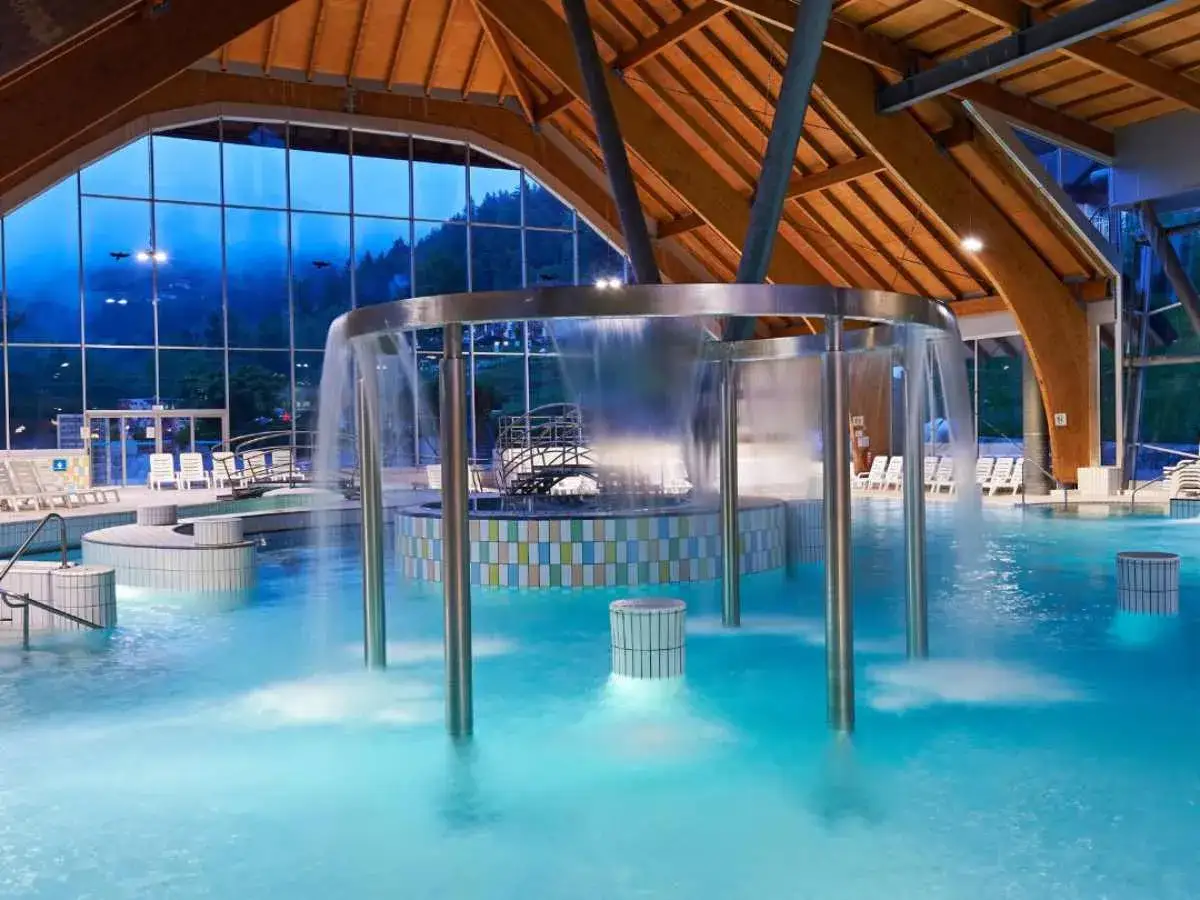 Piscina interna con cascata in moderne terme in Slovenia vicino al confine italiano. Relax e benessere assicurati.