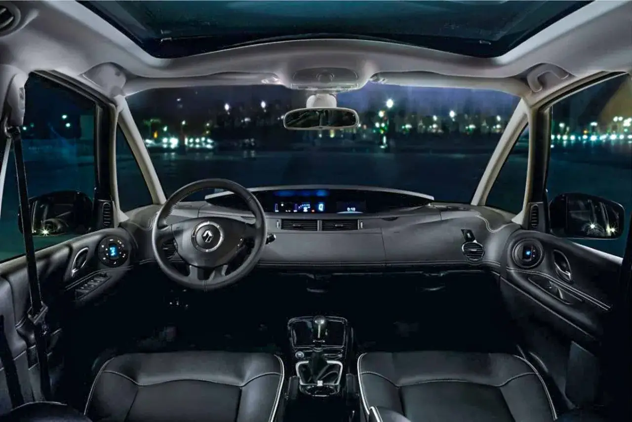 Wnętrze Renault Espace 4 nocą, widok z przodu na deskę rozdzielczą, kierownicę i fotele.