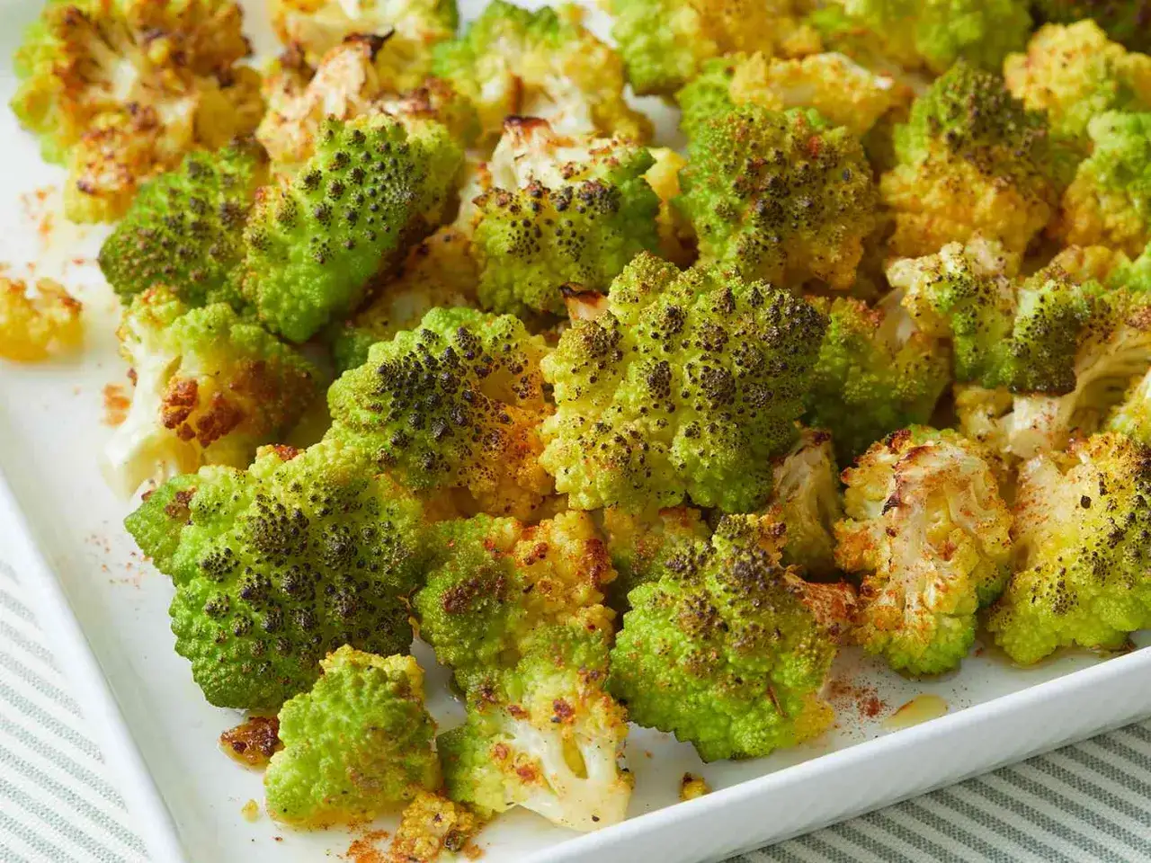 Ger&ouml;steter Romanesco, perfekt f&uuml;r ein einfaches und gesundes Romanesco Rezept. Die gr&uuml;nen R&ouml;schen sind leicht gebr&auml;unt und mit Gew&uuml;rzen bestreut.